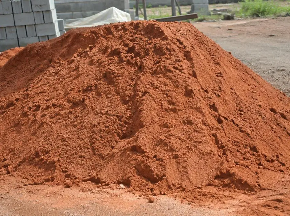 Heap of reddish-brown pit sand at a site yard